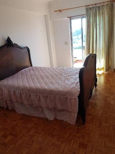 1 dormitorio con 1 cama y suelo de madera en Profiter,de,la,mer,et,de,Lisbonne,, en Alcabideche