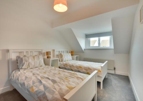 a bedroom with two beds and a window at Mena-Gwins in Padstow