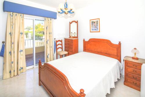 a bedroom with a bed and a dresser and a window at Olival Beach Villa with Pool walking distance to Beach in Armação de Pêra