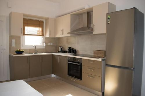 eine Küche mit einem Kühlschrank aus Edelstahl und einer Spüle in der Unterkunft Lazaros & Pagona Houses 2 in Ierápetra