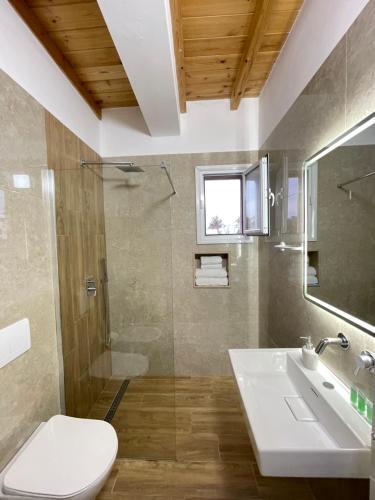a bathroom with a toilet and a sink and a shower at Maison Apartments in Vlorë