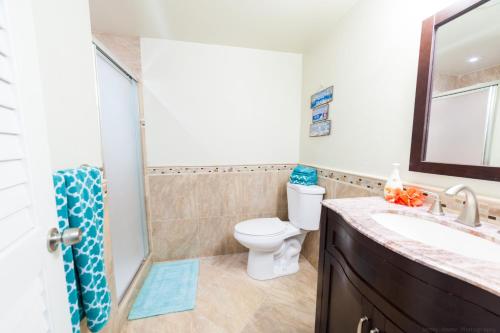 a bathroom with a toilet and a sink at Gorgeous Ocean Views! Welcome to Bella Breeze! BeachFront 2BR 2BA in Sion Farm