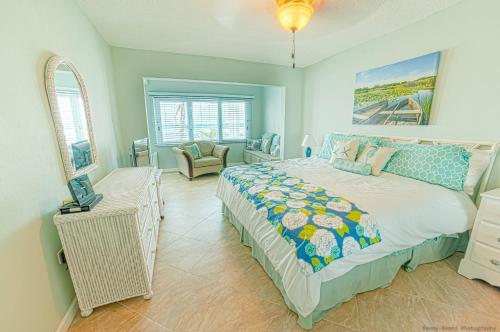 um quarto com uma cama e uma cadeira em Gorgeous Ocean Views! Welcome to Bella Breeze! BeachFront 2BR 2BA em Sion Farm