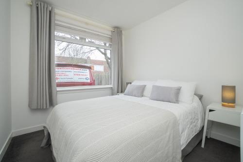 Un dormitorio blanco con una cama blanca y una ventana en Dwellcome Home Ltd 5 Bed 2 and half Bath Aberdeen House - see our site for assurance en Aberdeen