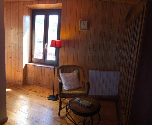 a room with a chair and a table and a lamp at Le Val Danse - Maison de caractère de 1870 - Rénovée en 2020 in Saint-Anthème