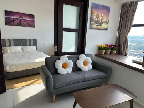 a living room with a couch with stuffed flowers on it at Beach Apartment @ Country Garden Danga Bay in Johor Bahru