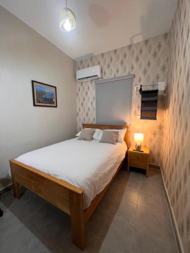 a bedroom with a bed and a lamp on a table at Hostal 53 Boutique Santo Domingo in Santo Domingo