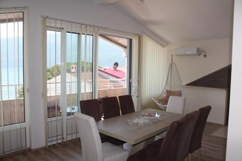 a dining room with a table and a view of the ocean at Panorama view apartment VANJA in Baošići