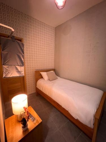 a bedroom with a bed and a table with a lamp at Hostal 53 Boutique Santo Domingo in Santo Domingo
