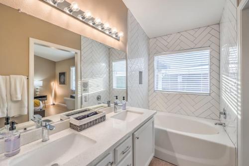 a bathroom with two sinks and a bath tub and a tubermott at Sunset Swim - Modern Vegas Heated Pool Retreat in Las Vegas
