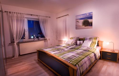 Schlafzimmer mit einem Bett und einem Fenster in der Unterkunft Ferienwohnung Gooß in Cuxhaven