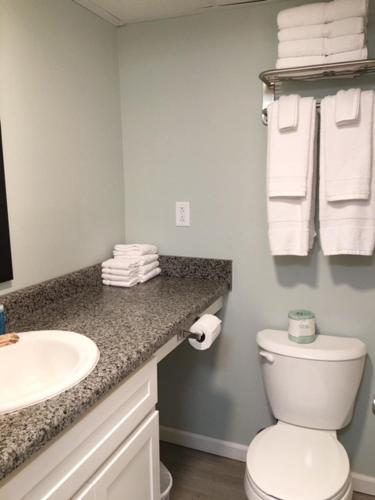 a bathroom with a sink and a toilet and towels at Ocean Plaza Motel in Myrtle Beach