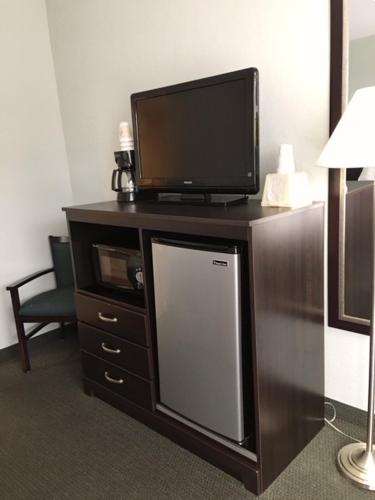 a flat screen tv on top of a wooden entertainment center at Ocean Plaza Motel in Myrtle Beach