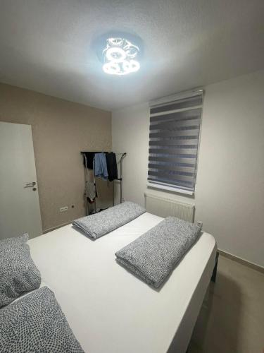 a bedroom with two beds and a light on the ceiling at Chill Apartment in Sarajevo