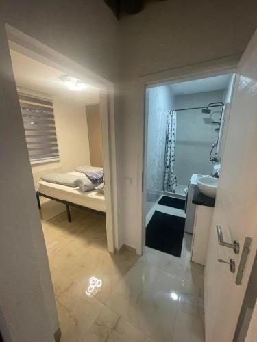 ein Bad mit einem Waschbecken und ein Bett in einem Zimmer in der Unterkunft Chill Apartment in Sarajevo