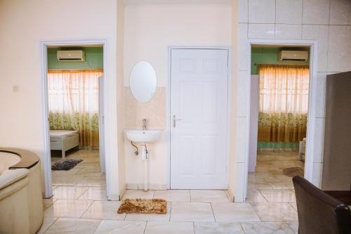 baño con lavabo y puerta blanca en Happy Holidays Style Residences, en Paramaribo