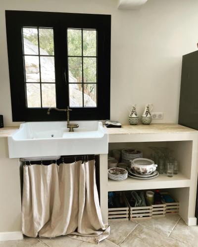 une cuisine avec un évier et une fenêtre dans l'établissement Casa di l’alivi, à Santa-Reparata-di-Balagna