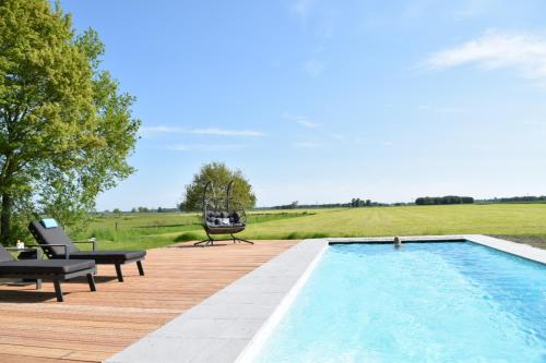 a swimming pool on a wooden deck with a helicopter hovering above it at Annense Pracht in Annen