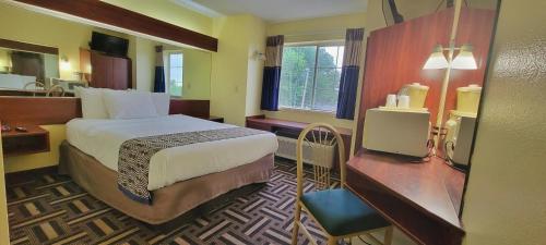 a hotel room with a bed and a desk at Microtel Inn & Suites by Wyndham Tulsa - Catoosa Route 66 in Tulsa