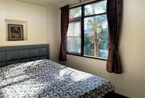 a bedroom with a bed and a window at Taphouse in Hua Hin