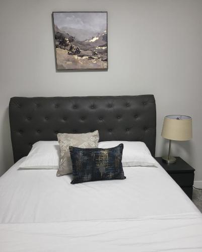 Luxury suite in Calgary NW في كالغاري: غرفة نوم مع سرير كبير مع اللوح الأمامي الأسود