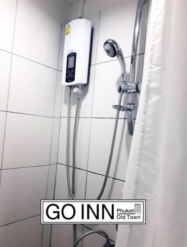 a shower in a bathroom with a go inn sign at GO INN Phuket Old Town ภูเก็ตโอลทาวน์ ย่านเมืองเก่า in Phuket