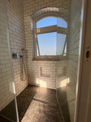 a bathroom with a shower and a window at בקצה הנוף in Kefar Szold