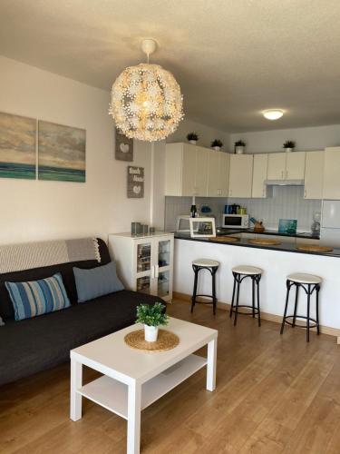 een woonkamer en een keuken met een bank en een tafel bij Blue relax Candelaria in Candelaria
