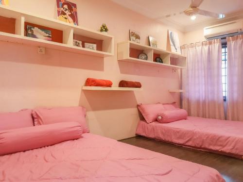 two beds in a room with pink sheets at 5BR IndoorPrivate Pool Villa BathTub BBQ Steamboat in Melaka