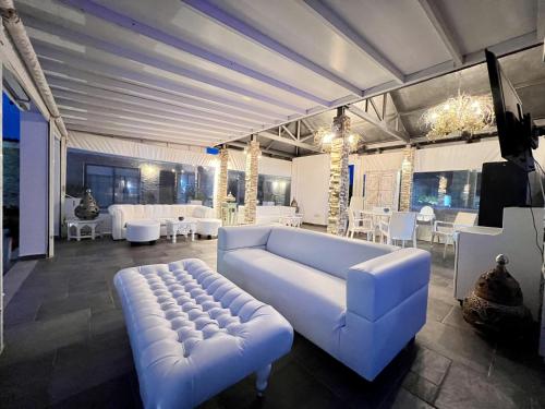 duży salon z białą kanapą i stołami w obiekcie Cape Serenity Mansion w Ajia Napa