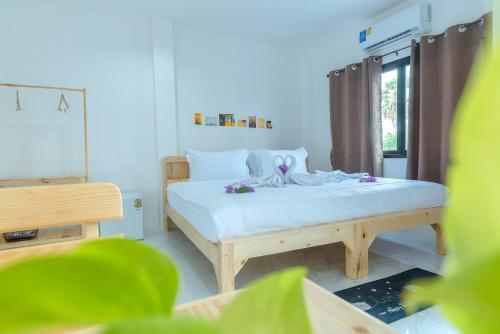 a small bedroom with a bed and a window at Phanomrung Hostel & Linn Chan Cafe พนมรุ้ง โฮส์เทล แอนด์ ลิณณ์จัง คาเฟ่ in Buriram