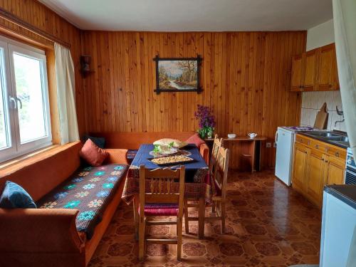 a kitchen with a couch and a table in a room at Čemerno Cottage in Gacko