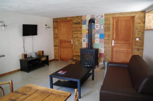 a living room with a couch and a stove at Appartement Dans Chalet de Montagne in Bozel