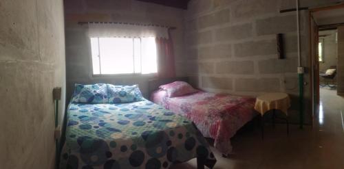 a small bedroom with a bed and a window at Soki in Guatapé