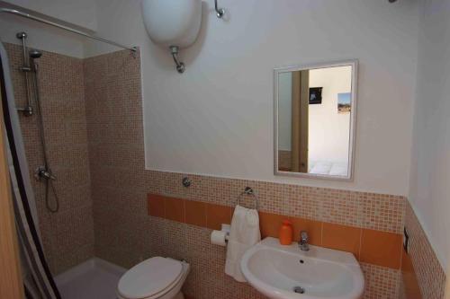 a bathroom with a sink and a toilet and a mirror at B&B Le Dune Beach in San Leone