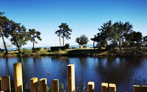 ein Wasserkörper mit einem Zaun davor in der Unterkunft Le Bungalow du Ferret - Mobil Home Premium avec vue bassin d'Arcachon in Claouey