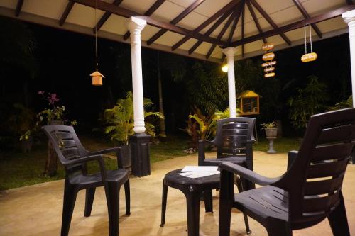a group of chairs and tables under an umbrella at Nature World Jungle Paradise in Udawalawe