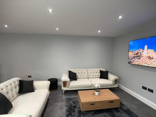 a living room with two couches and a tv at Newly refurbished 4 Bedroom House-Sleep 8-Free parking in Canvey