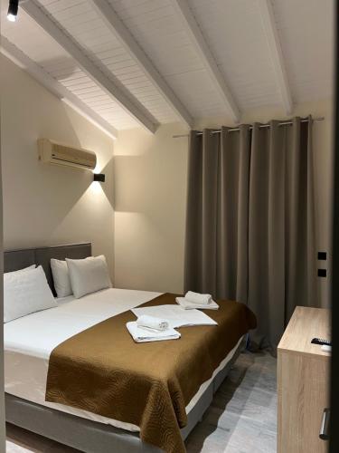 a bedroom with a bed with two towels on it at Saint Spiridon Hotel in Kassiopi