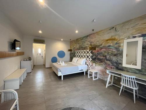 um quarto com uma cama e uma parede em Irina Beach Hotel em Tigaki