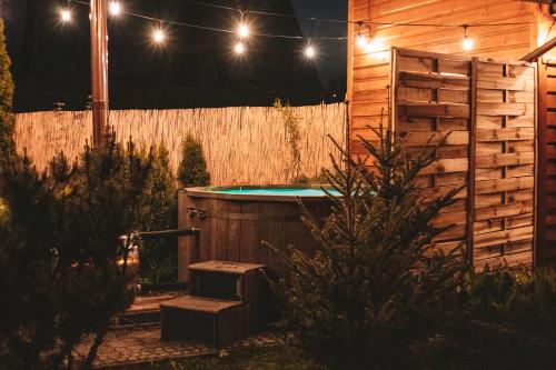a hot tub in a backyard at night with lights at Poddasze dla Znajomych - apartament z gorącą balią in Kluszkowce