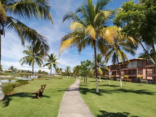 einen Weg durch einen Park mit Palmen in der Unterkunft Apartamento no Condomínio Vila das Águas in Estância