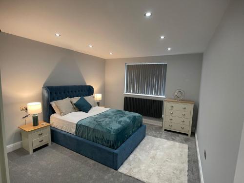 a bedroom with a blue bed and a window at Newly refurbished 4 Bedroom House-Sleep 8-Free parking in Canvey
