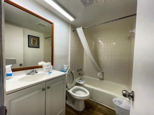 a bathroom with a sink and a toilet and a tub at Oceanfront Viking Motel in Myrtle Beach