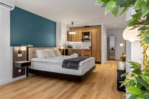 ein Schlafzimmer mit einem Bett und einer blauen Wand in der Unterkunft Uni88 Apart Hotel in Bukarest