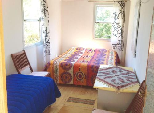 um quarto com uma cama, uma cadeira e 2 janelas em Exotic Vacation Home em Telti