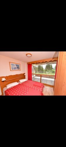 una camera con letto rosso e finestra di Appartement 6 couchages avec terrasse a Chamrousse