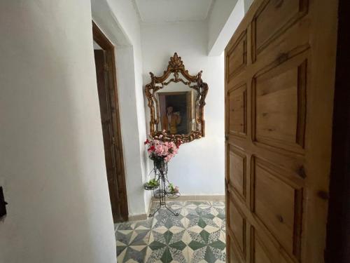 a hallway with a mirror and a vase of flowers at Au cœur du Médina in Fez