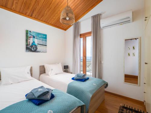 a bedroom with two beds and a window at Villa Aura Pine in Agia Pelagia