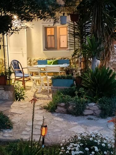 a patio with a table and chairs in a yard at Cala Creta in Lampedusa